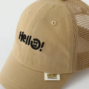 Detail of khaki mesh sun hat featuring smiley face embroidery and breathable fabric