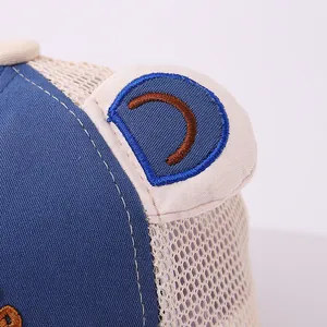 Detail of baby mesh cap featuring cute animal ears with brown embroidery and breathable mesh