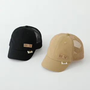 Detail of toddler trucker hats showing mesh back and bear patch on short brim caps