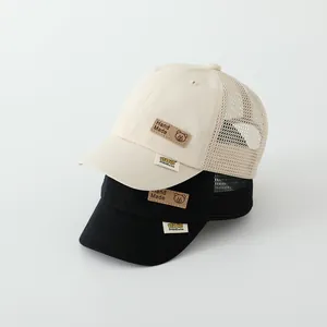 Detail of breathable summer kids mesh baseball cap with bear patch and leather label