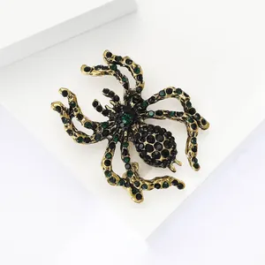 Macro detail of retro spider brooch with dark green and black rhinestones in gold finish