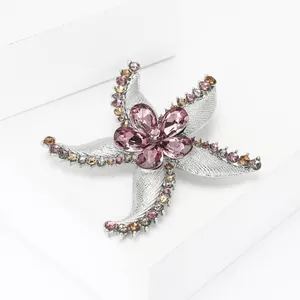 Detail of starfish brooch with crystal flower and shimmering metallic finish