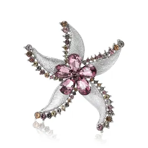 Elegant rhinestone starfish brooch with pink gemstone flower center and silver texture