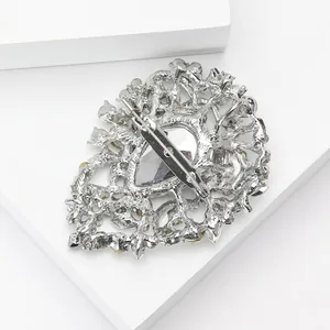 Detail of silver drop brooch with hollow metalwork and yellow crystal rhinestones
