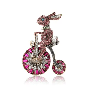 Luxe strass konijn op fiets broche met roze en witte kristallen op gouden basis