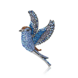 Broche oiseau lourde ornée de strass bleus et violets éclatants sur métal argenté