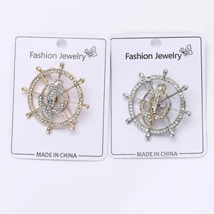 Detail view of nautical helm and anchor brooches with sparkling inlaid rhinestones