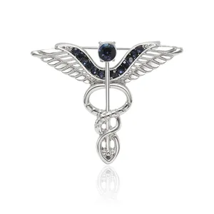 Broche médicale caducée en argent avec strass bleus et ailes détaillées en relief