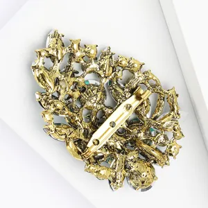 Macro shot of the back of a vintage alloy brooch with golden finish and safety pin detail