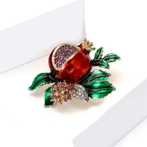 Exquisite pomegranate brooch with red enamel and purple crystals on a golden alloy base
