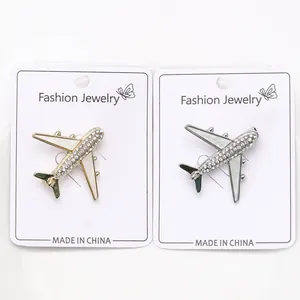 Detail of creative rhinestone aircraft brooches in gold and silver finish with enamel wings