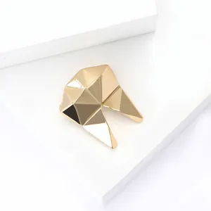 Minimalist gold geometric tooth-shaped alloy brooch with a polished faceted metal finish