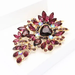 Macro detail of alloy brooch with deep purple heart crystal and golden finish plating