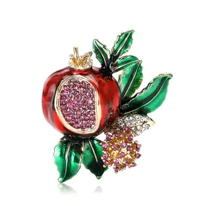 Exquisite pomegranate brooch with red enamel and crystals on a white background
