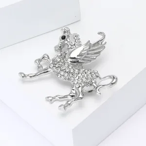 Detailaufnahme einer silbernen Pegasus-Brosche mit funkelnden Strasssteinen und Edelstein