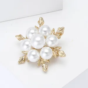 Élégante broche fleur dorée avec perles blanches et pétales en forme de flocon de neige