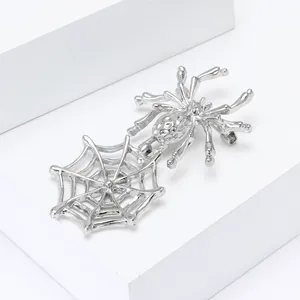 Détail de la broche toile d'araignée argentée avec araignée texturée sur support blanc