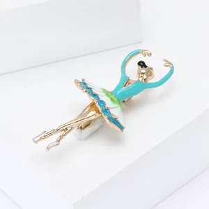 Detailed close-up of a golden ballerina brooch with blue and white enamel tutu