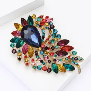 Détail d'une broche dorée élégante avec gemme bleue et cristaux multicolores brillants