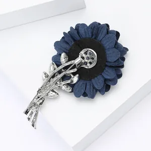 Detailed view of dark blue fabric flower brooch with silver alloy leaf base and pin