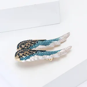 Broche ailes d'ange élégante en alliage doré avec strass bleus et détails en émail