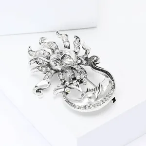 Broche vintage soleil lune en argent avec strass sur un socle blanc minimaliste