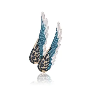 Broche ailes d'ange élégante avec cristaux bleus et finition en émail blanc pour femme