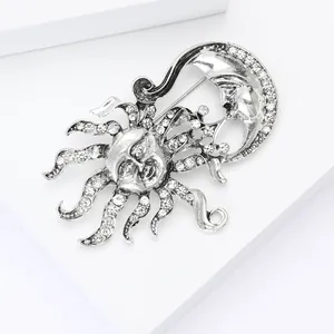 Détail de la broche vintage en argent avec soleil, lune et strass brillants incrustés