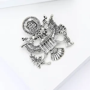 Detail view of vintage eagle shield brooch with embossed textured metal and antique finish