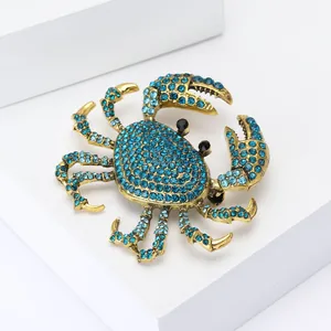 Broche crabe vintage dorée sertie de strass bleu ciel avec des yeux en pierres noires