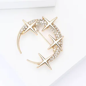 Detailed close-up of golden crescent moon and star brooch with sparkling rhinestones