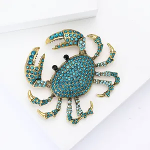 Détail d'une broche crabe avec strass bleus et finition dorée de style vintage