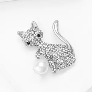 Détail macro d'une broche chat sertie de strass avec perle sur métal argenté brillant