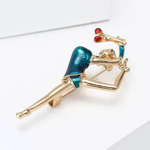 Enamel dancing girl brooch in gold finish with blue and red gymnast motif on white stand