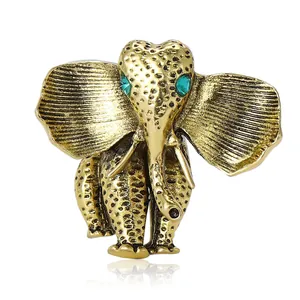 Vintage elephant brooch in gold-tone alloy with green gem eyes for suits and coats