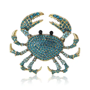 Broche crabe exquise plaquée or avec cristaux bleus éclatants et yeux en perles noires