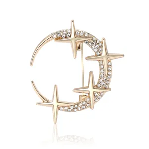 Elegant gold celestial crescent moon and star brooch with sparkling rhinestones on white
