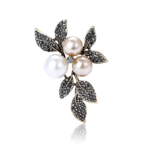 Vintage gold alloy brooch with pearls and black rhinestones in an elegant leaf design