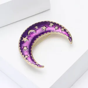 Close-up of crescent moon enamel brooch with purple finish and golden star details
