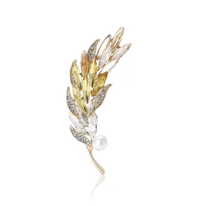 Elegant gold wheat brooch with sparkling yellow crystals and a white pearl on white base