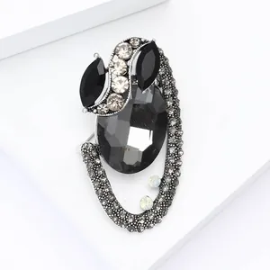 Close-up of vintage oval grey rhinestone brooch with silver alloy base and black gems