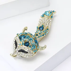 Macro detail of elegant gold fox brooch with blue rhinestones on a white pedestal