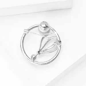 Macro-opname van zilveren ronde broche met veiligheidsspeld op geometrisch display