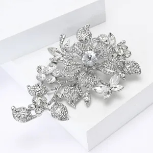 Macro shot of silver crystal flower brooch with rhinestone petals on white pedestals
