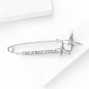 Macro shot of silver safety pin brooch with sparkling crystals and star motifs