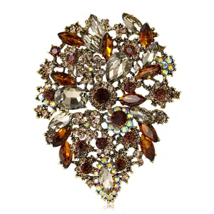 Vintage alloy brooch with amber crystals and rhinestones in flower shape on white background