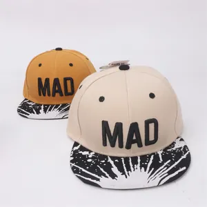 Détail de casquettes baseball enfant broderie MAD avec motifs d'éclaboussures d'encre