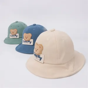 Dettaglio dei cappelli a secchiello in velluto per neonati con patch Lucky