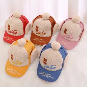 Collection of five colorful corduroy baby winter hats with ear flaps and bear embroidery