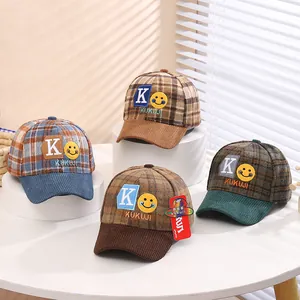 Detail view of four kids' checkered baseball caps with K letter and smiley face embroidery